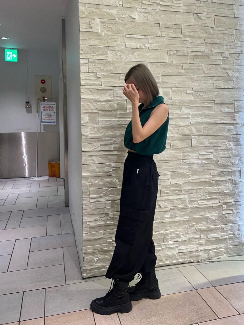 ブラック系のタンクトップ、パープル系のカーゴパンツ、ブラック系のブーツを着用したレディースの春コーディネートの3枚目の写真