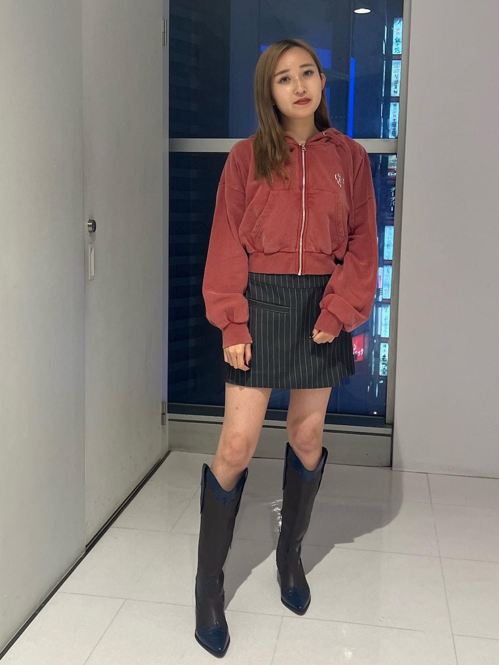 グレー系のテーラードジャケット、グレー系のスカート、レッド系のスウェットを着用したレディースの秋コーディネートの7枚目の写真