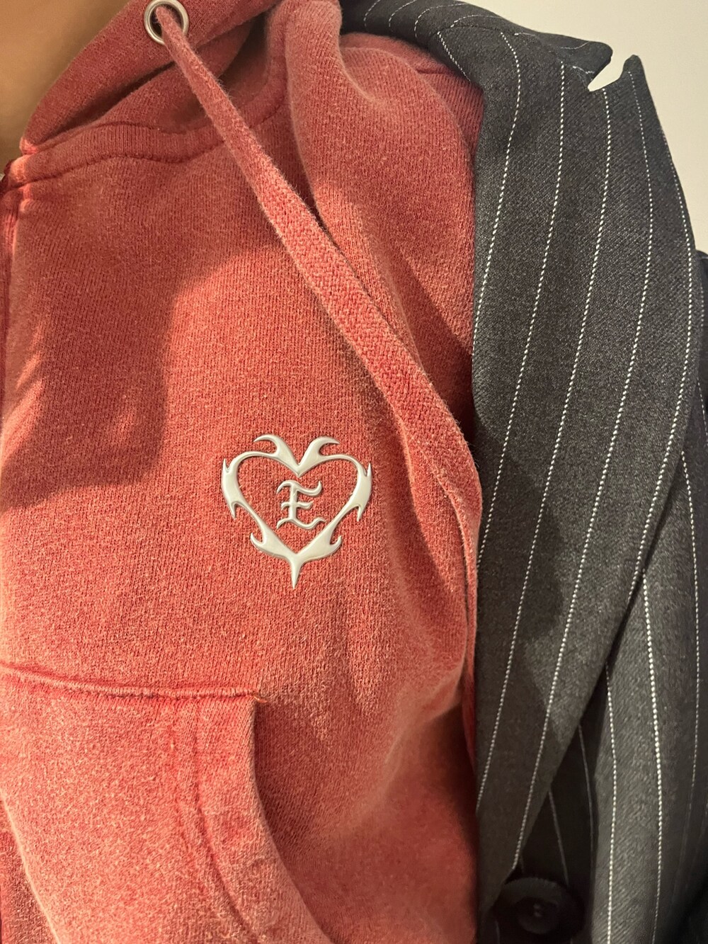 グレー系のテーラードジャケット、グレー系のスカート、レッド系のスウェットを着用したレディースの秋コーディネートの6枚目の写真