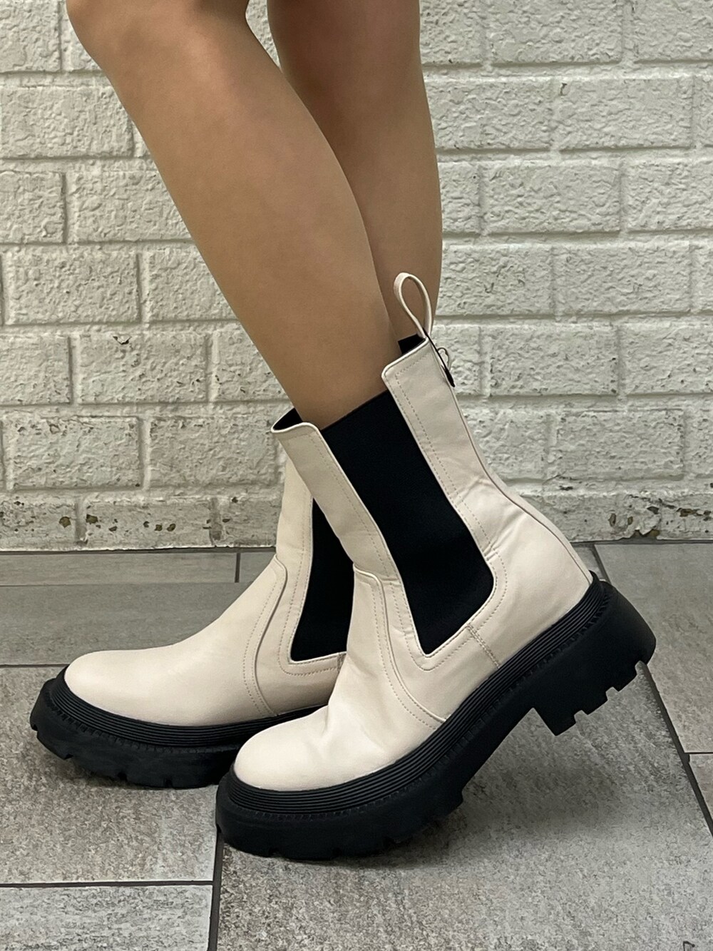 ホワイト系のブーツ、ブラック系のその他パンツ、ホワイト系のニット/セーターを着用したレディースの冬コーディネートの4枚目の写真