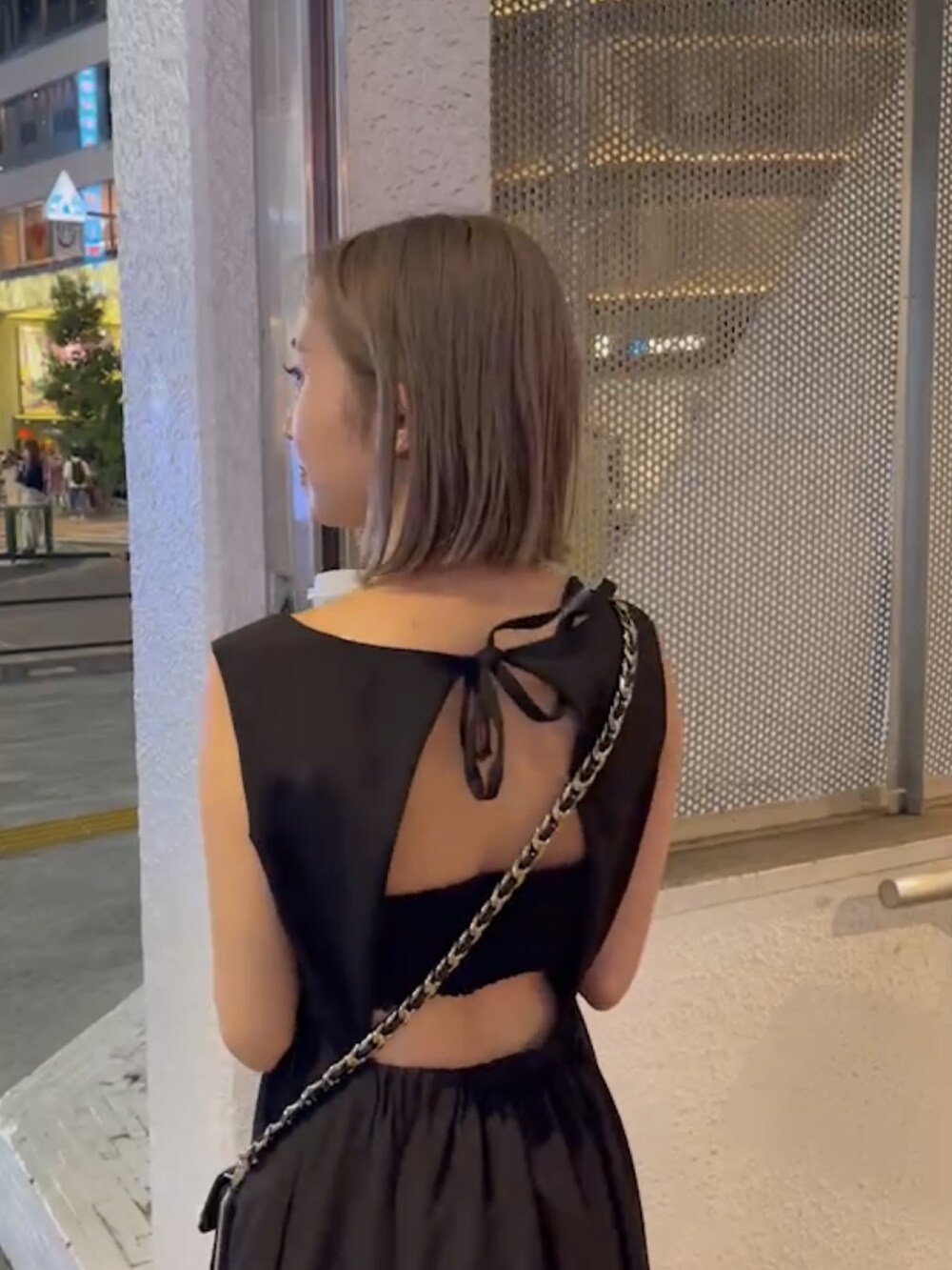 ブラック系のワンピース、ブラック系のショルダーバッグ、ホワイト系のサンダルを着用したレディースの夏コーディネートの7枚目の写真