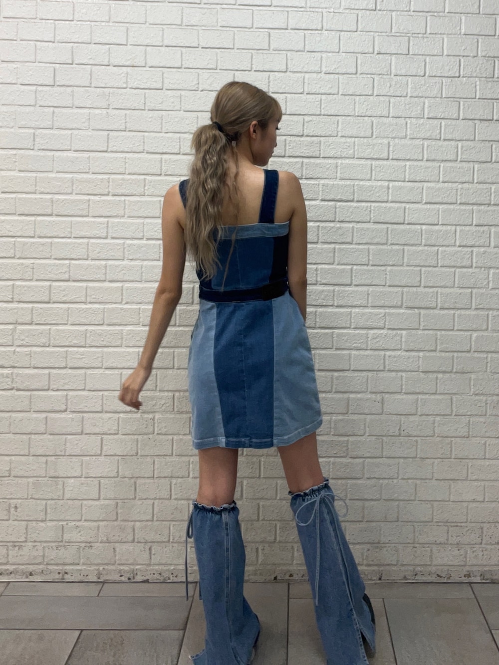 ブルー系のワンピース、ブラック系のブーツ、ブルー系のレッグウォーマーを着用したレディースの夏コーディネートの3枚目の写真