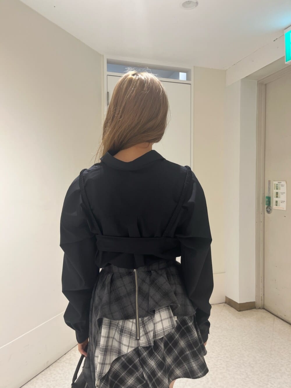 ブラック系のブーツ、ブラック系のボストンバッグ、ブラック系のスカートを着用したレディースの春コーディネートの6枚目の写真