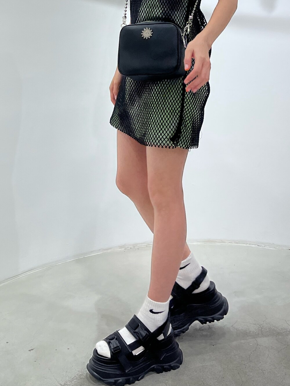 グリーン系のワンピース、ブラック系のサンダル、ブラック系のショルダーバッグを着用したレディースの春コーディネートの8枚目の写真