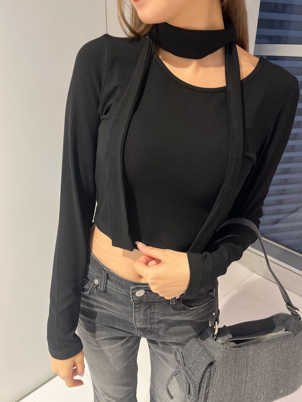 ブラック系のデニムパンツ、ブラック系のハンドバッグ、ブラック系のブーツを着用したレディースの秋コーディネートの5枚目の写真