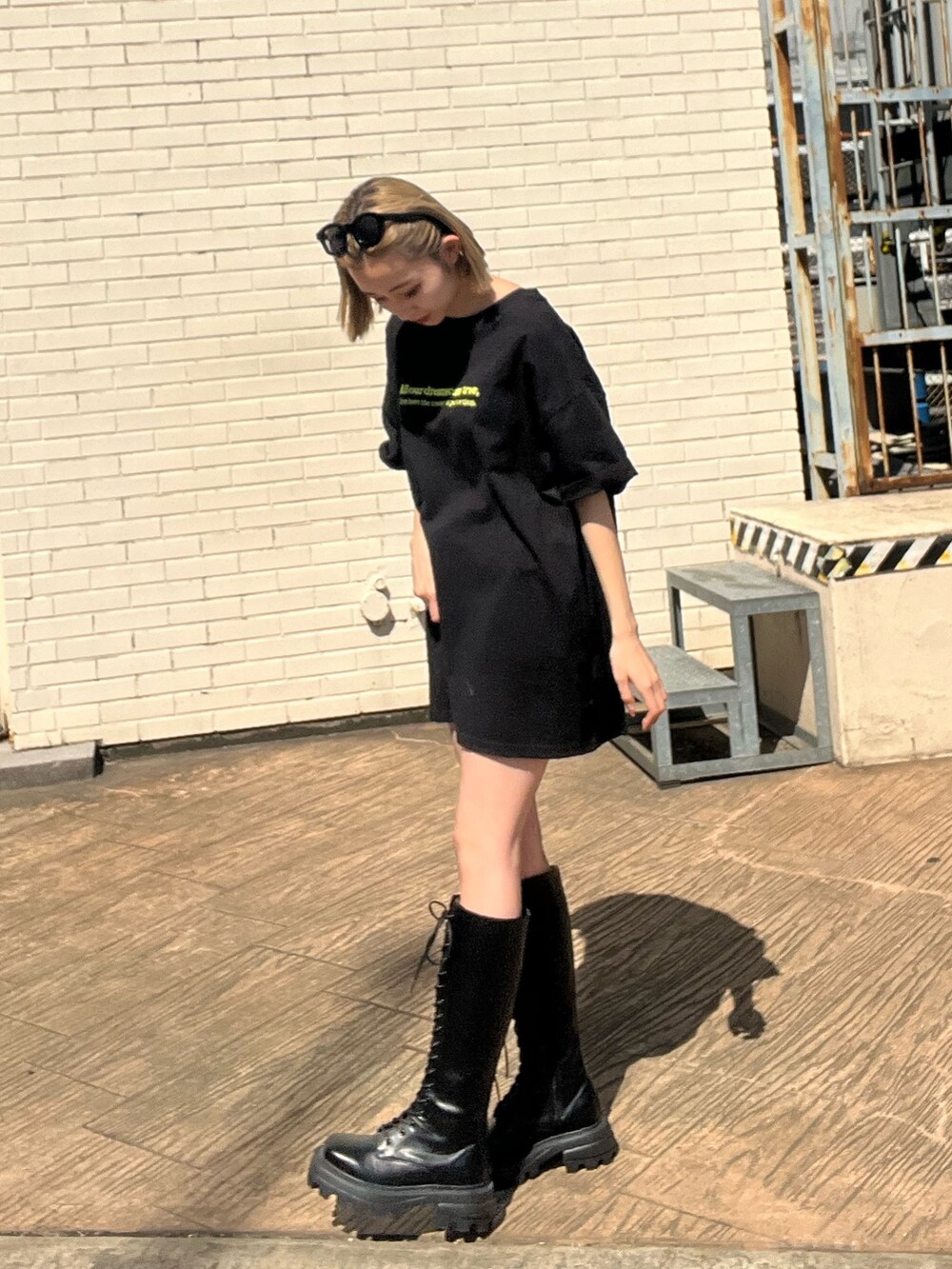 ブラック系のTシャツ/カットソー、ブラック系のブーツ、ブラック系のサングラスを着用したレディースの春コーディネートの3枚目の写真