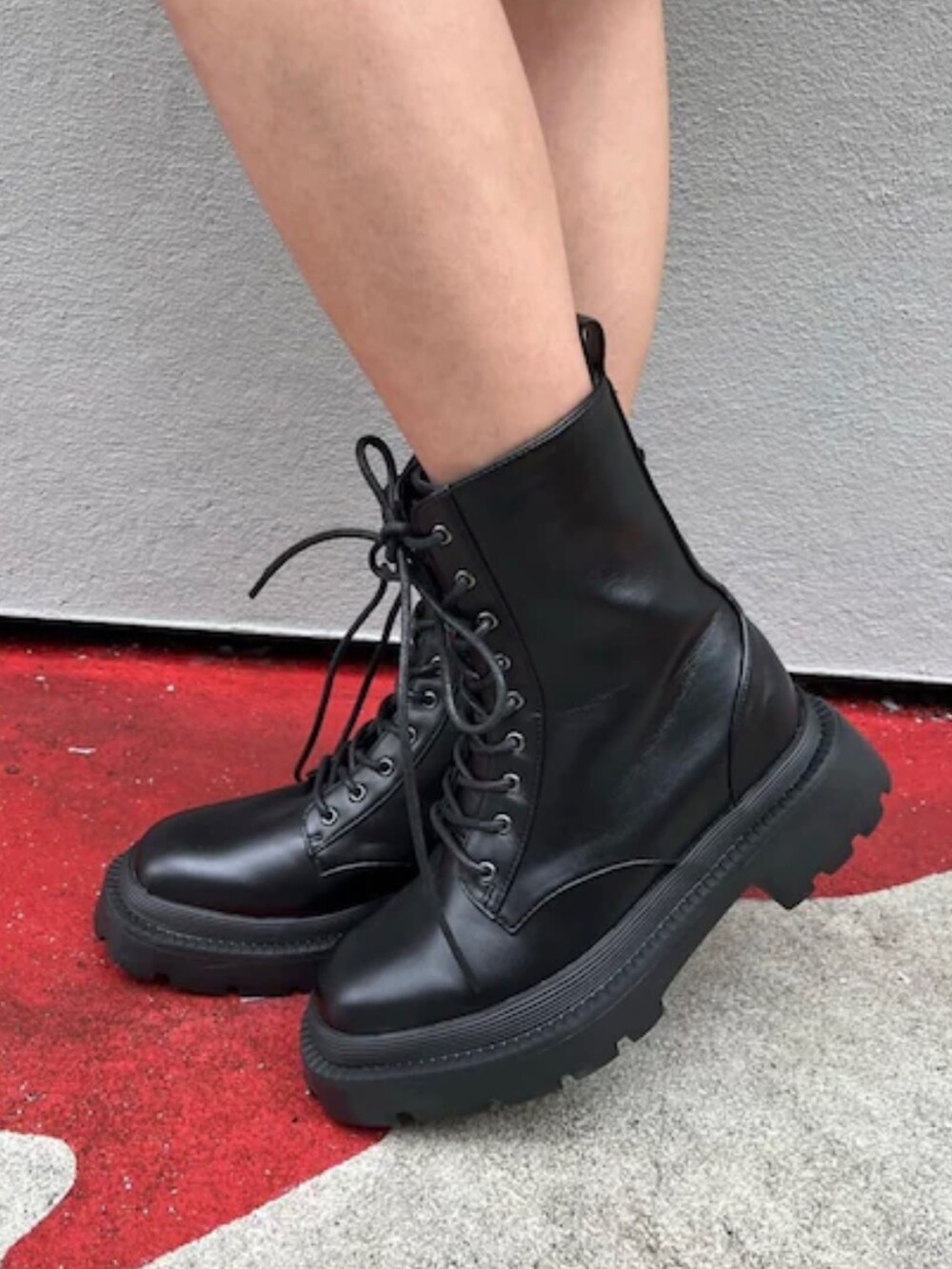 オレンジ系のカーゴパンツ、ブラック系のブーツ、パープル系のチューブトップを着用したレディースの春コーディネートの6枚目の写真