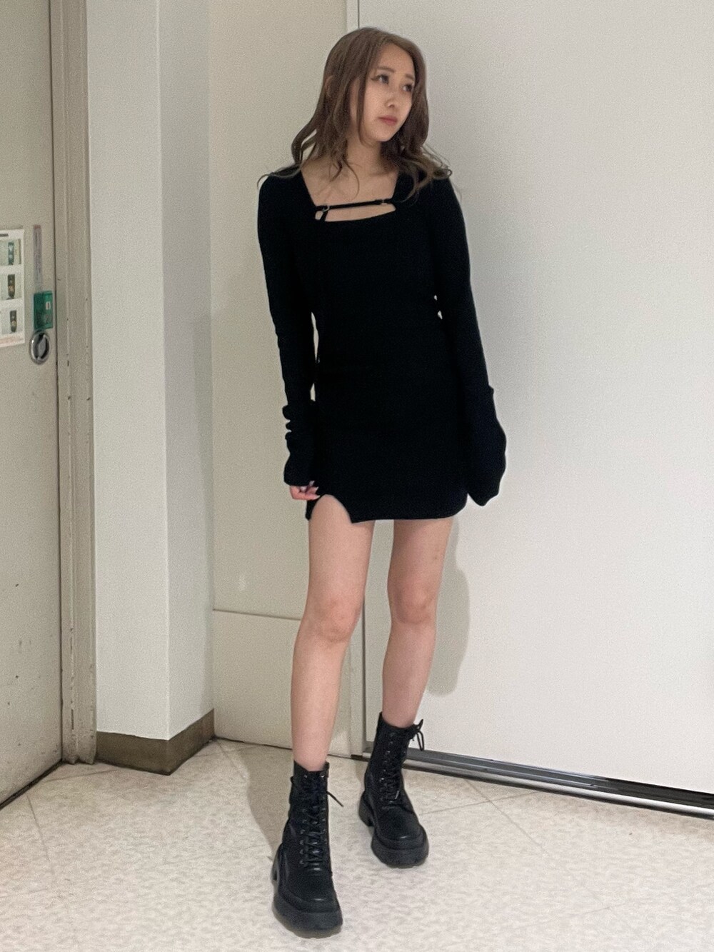 ブルー系のデニムジャケット、ブラック系のワンピース、ブラック系のブーツを着用したレディースの春コーディネートの6枚目の写真