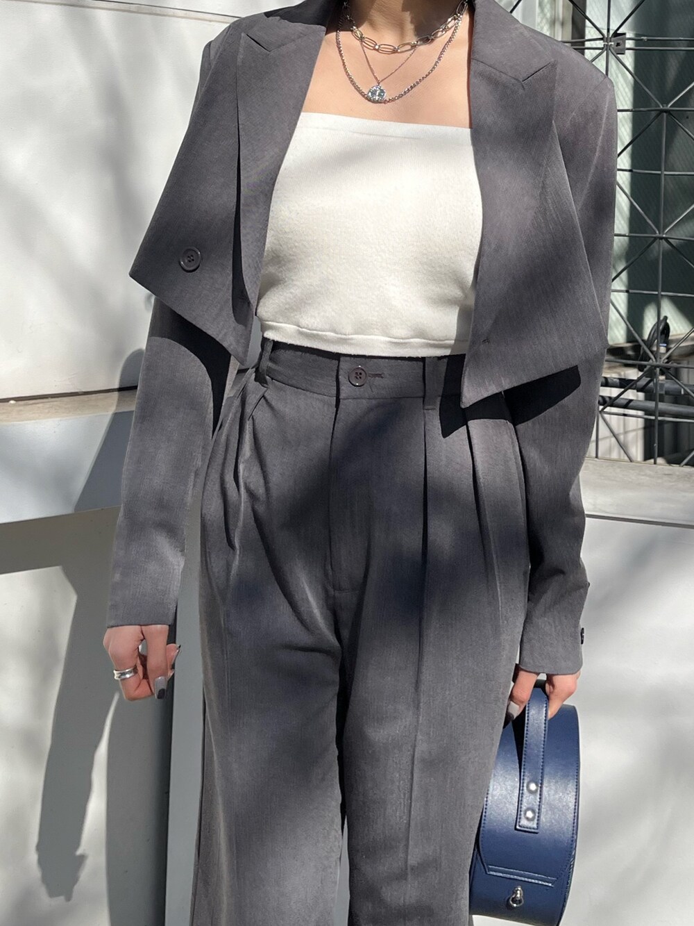 グレー系のテーラードジャケット、グレー系のその他パンツ、ブラック系のショルダーバッグを着用したレディースの春コーディネートの4枚目の写真