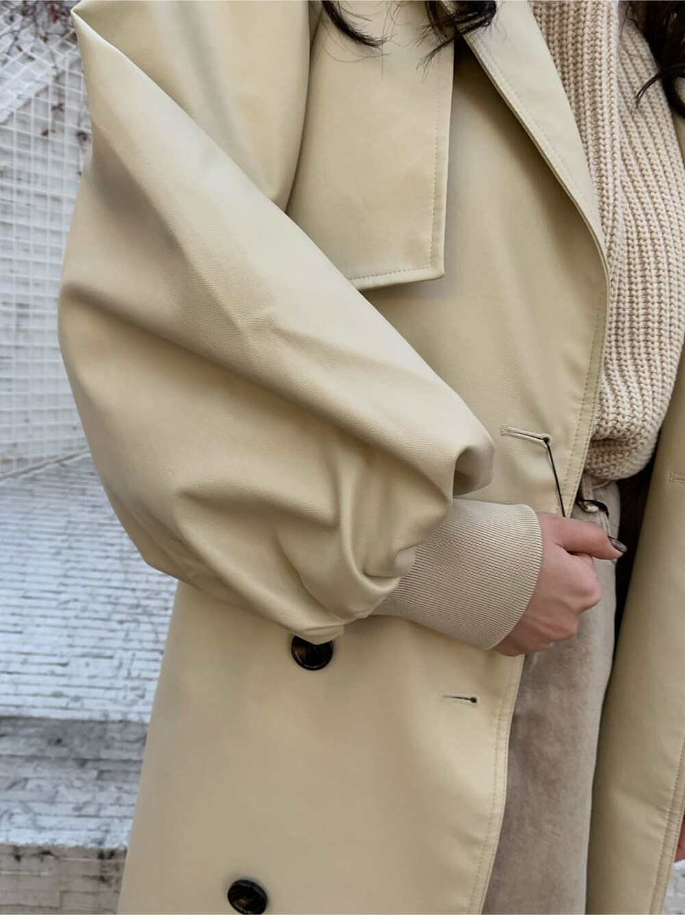 ブラウン系のブーツ、ベージュ系のTシャツ/カットソー、ホワイト系のトレンチコートを着用したレディースの冬コーディネートの3枚目の写真