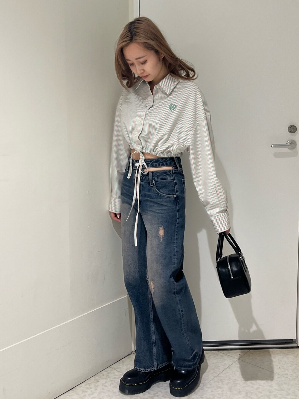 ブルー系のシャツ/ブラウス、ブルー系のデニムパンツ、ブラック系のブーツを着用したレディースの春コーディネートの2枚目の写真