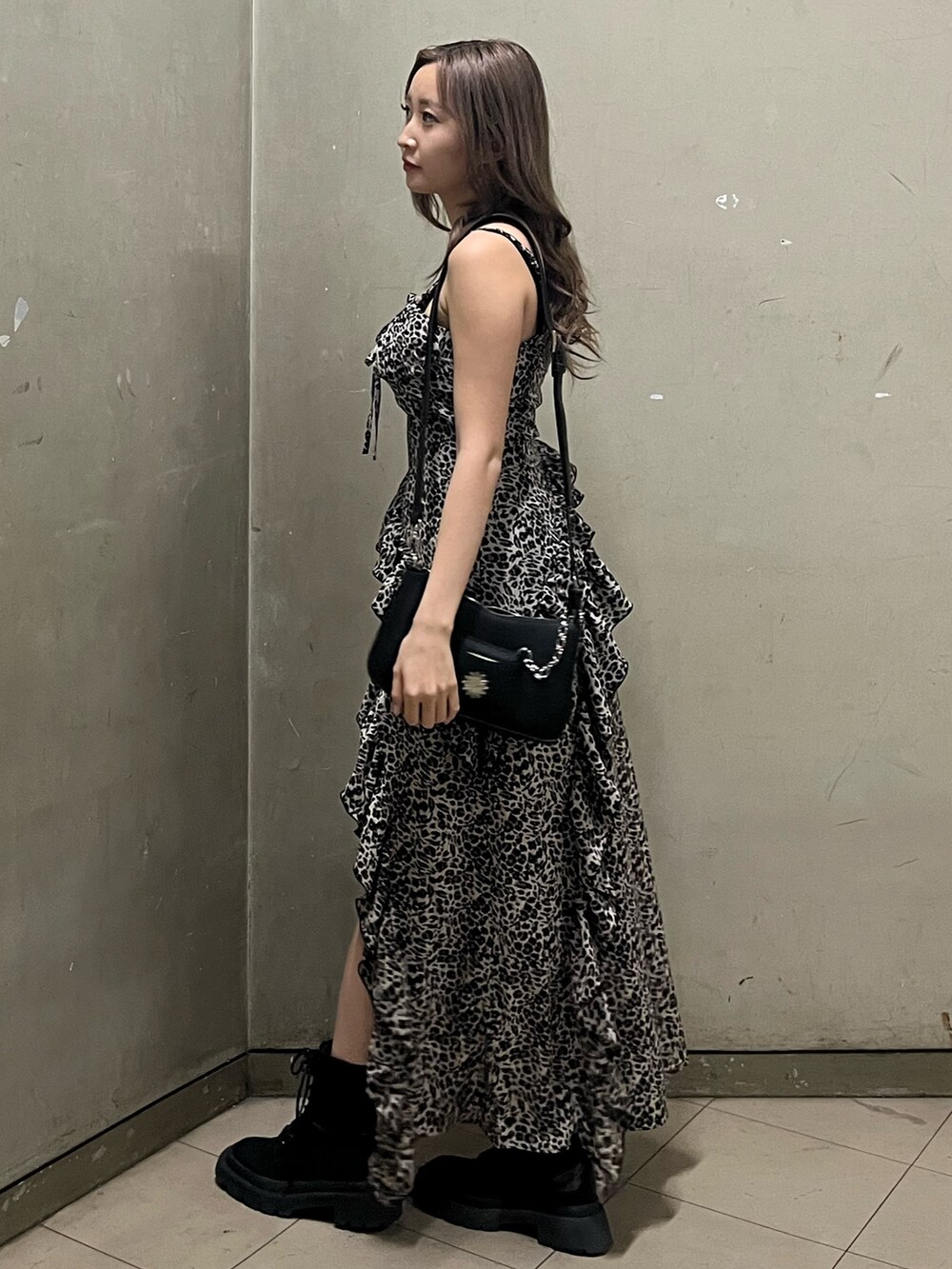ブラック系のショルダーバッグ、ブラック系のブーツ、その他のワンピースを着用したレディースの春コーディネートの2枚目の写真