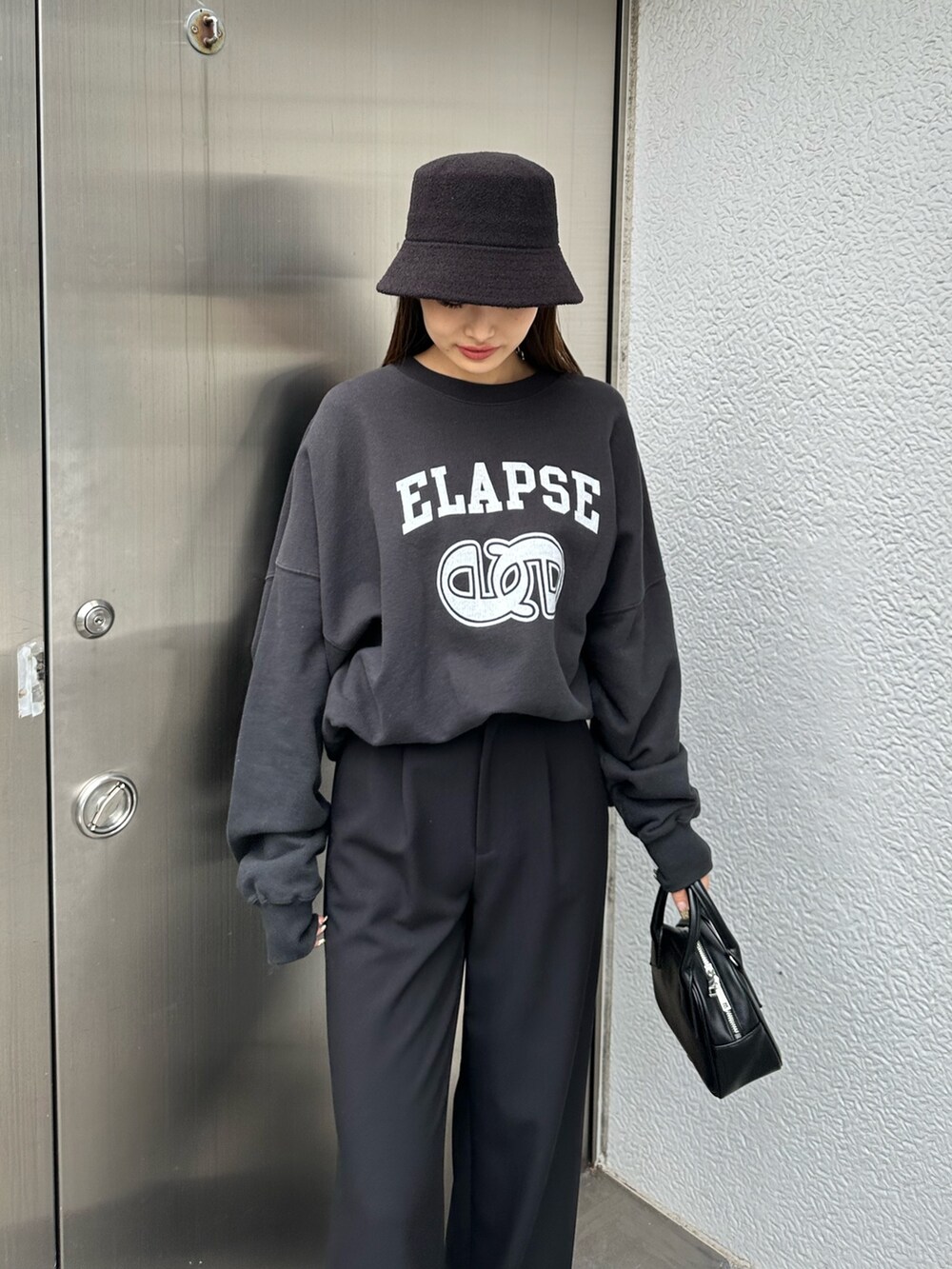 ブラック系のその他パンツ、ブラック系のハンドバッグ、ブラック系のTシャツ/カットソーを着用したレディースの冬コーディネートの4枚目の写真
