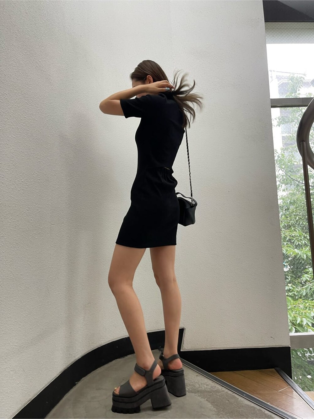 ブラック系のワンピース、グレー系のサンダルを着用したレディースの夏コーディネートの3枚目の写真