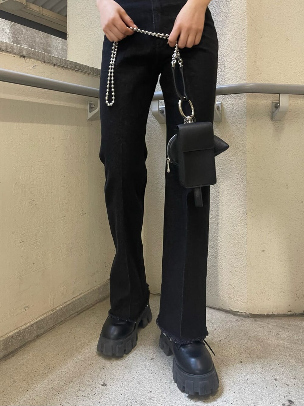 ブラック系のブーツ、ブラック系のハンドバッグ、ブラック系のデニムパンツを着用したレディースの春コーディネートの10枚目の写真