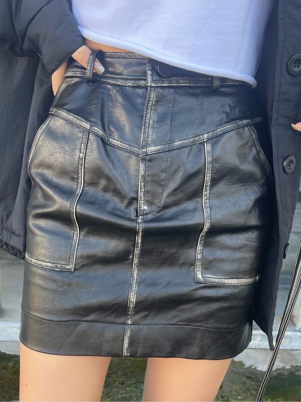 ブラック系のブルゾン、ブラック系のスカート、ホワイト系のTシャツ/カットソーを着用したレディースの秋コーディネートの6枚目の写真