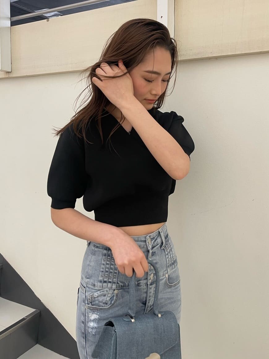 ブラック系のニット/セーター、ブルー系のハンドバッグ、ブラック系のサンダルを着用したレディースの春コーディネートの3枚目の写真