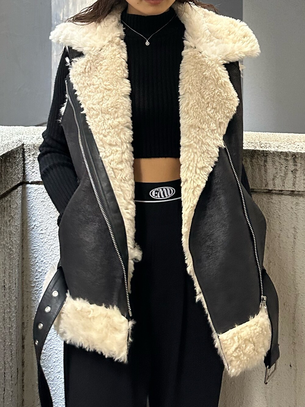 ブラック系のその他パンツ、ブラック系のブーツ、ブラック系のムートンコートを着用したレディースの秋コーディネートの5枚目の写真