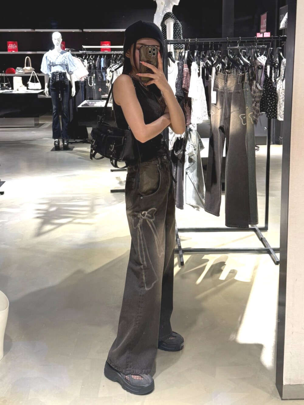 ブラック系のデニムパンツ、ブラック系のTシャツ/カットソー、グレー系のスニーカーを着用したレディースの夏コーディネートの2枚目の写真