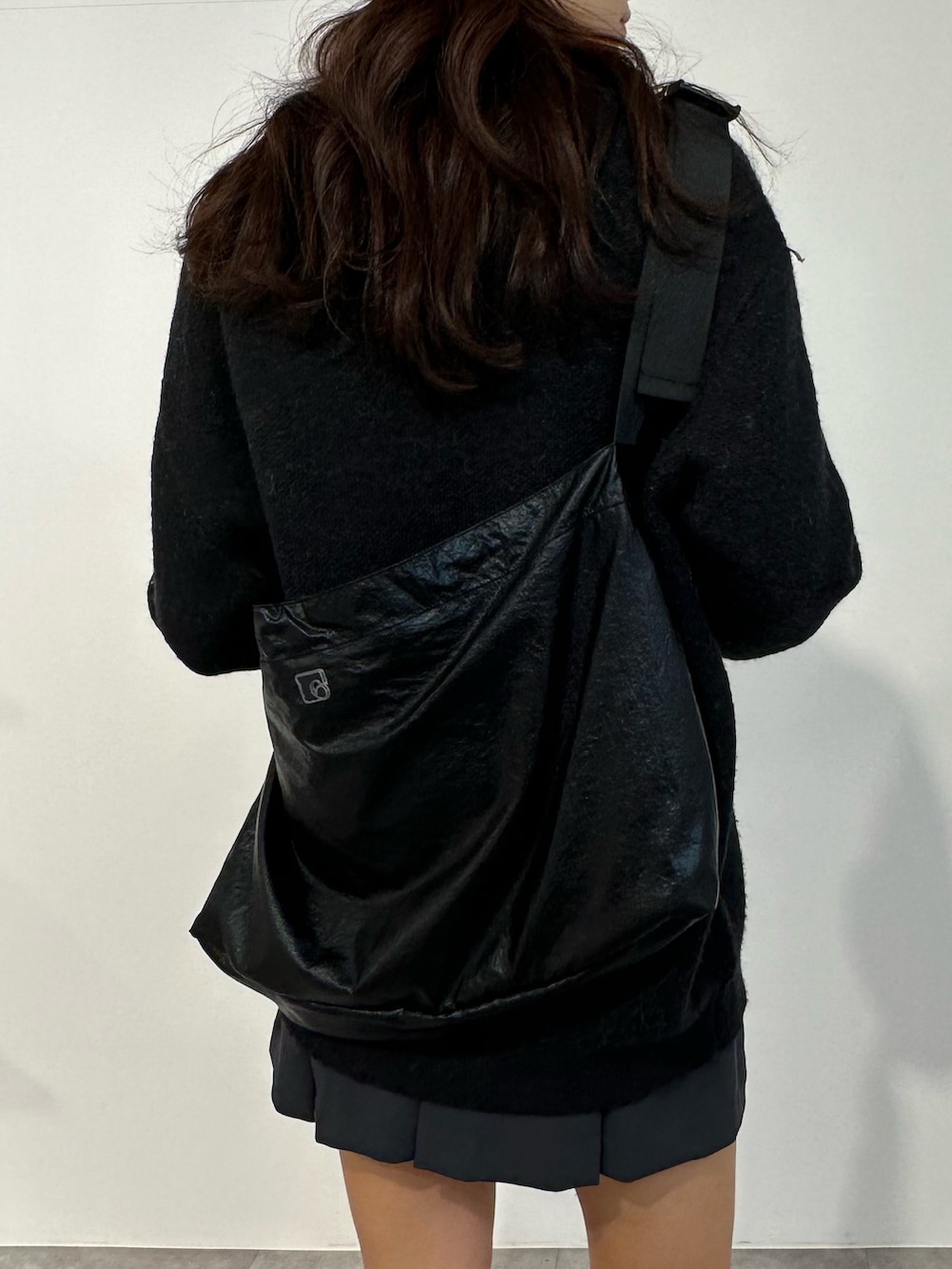 ブラック系のニット/セーター、グレー系のスカート、ブラック系のブーツを着用したレディースの冬コーディネートの5枚目の写真