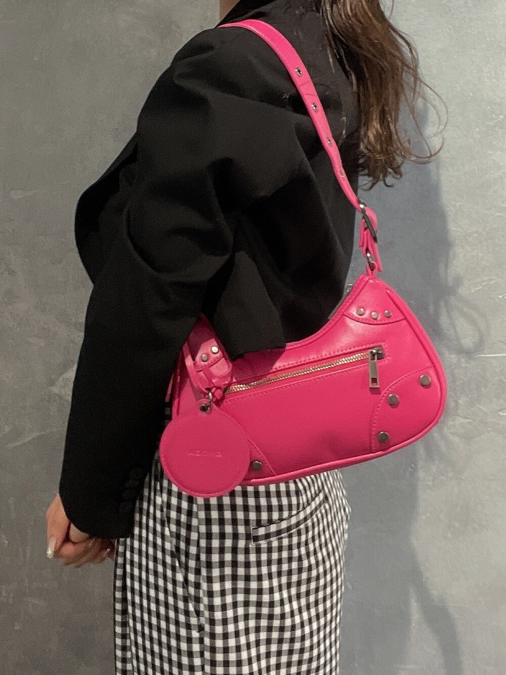 ピンク系のハンドバッグ、ブラック系のパンプス、ブラック系のテーラードジャケットを着用したレディースの冬コーディネートの5枚目の写真