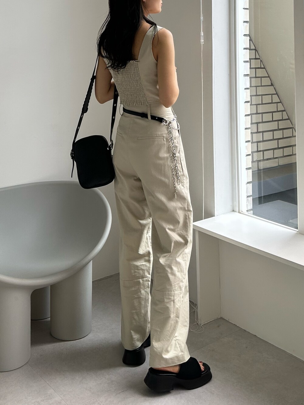 ホワイト系のその他パンツ、ホワイト系のキャミソール、ブラック系のショルダーバッグを着用したレディースの夏コーディネートの3枚目の写真