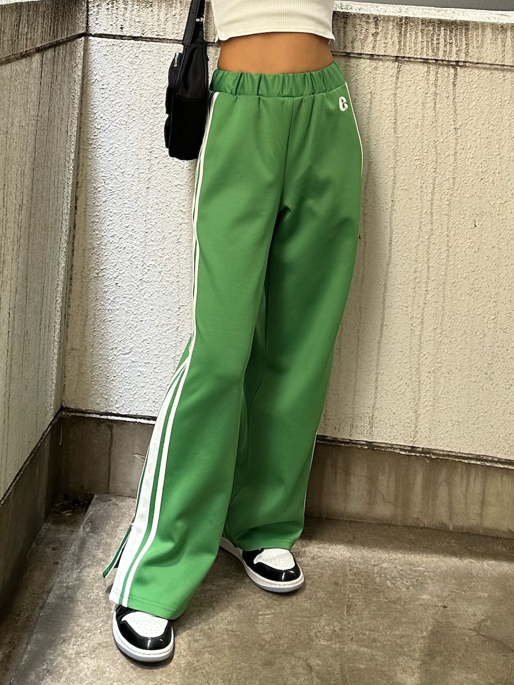 ホワイト系のタンクトップ、グリーン系のその他パンツ、ブラック系のハンドバッグを着用したレディースの秋コーディネートの3枚目の写真