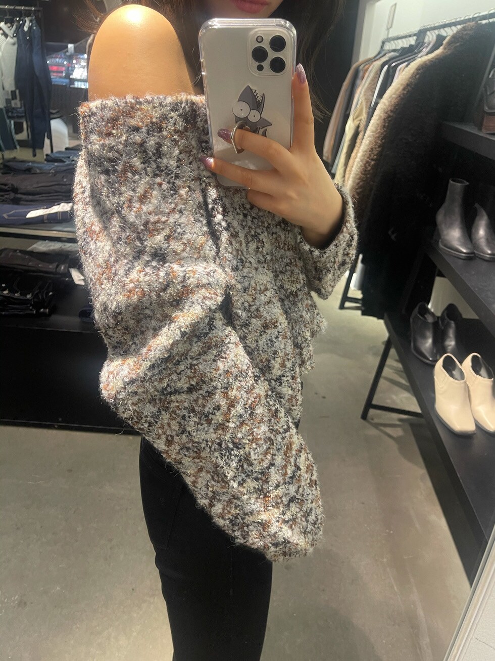 ブラック系のブーツ、ブラック系のデニムパンツ、ホワイト系のニット/セーターを着用したレディースの冬コーディネートの3枚目の写真