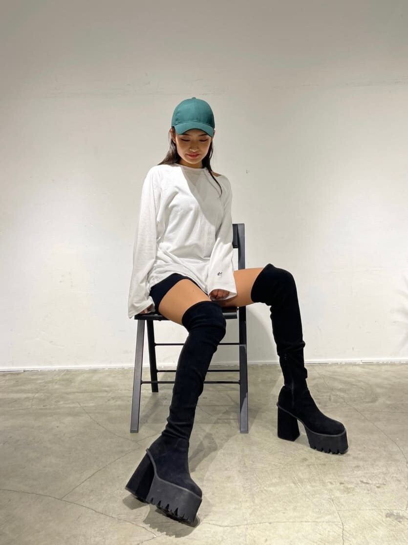 ブラック系のスカート、ブラック系のブーツを着用したレディースの夏コーディネートの2枚目の写真