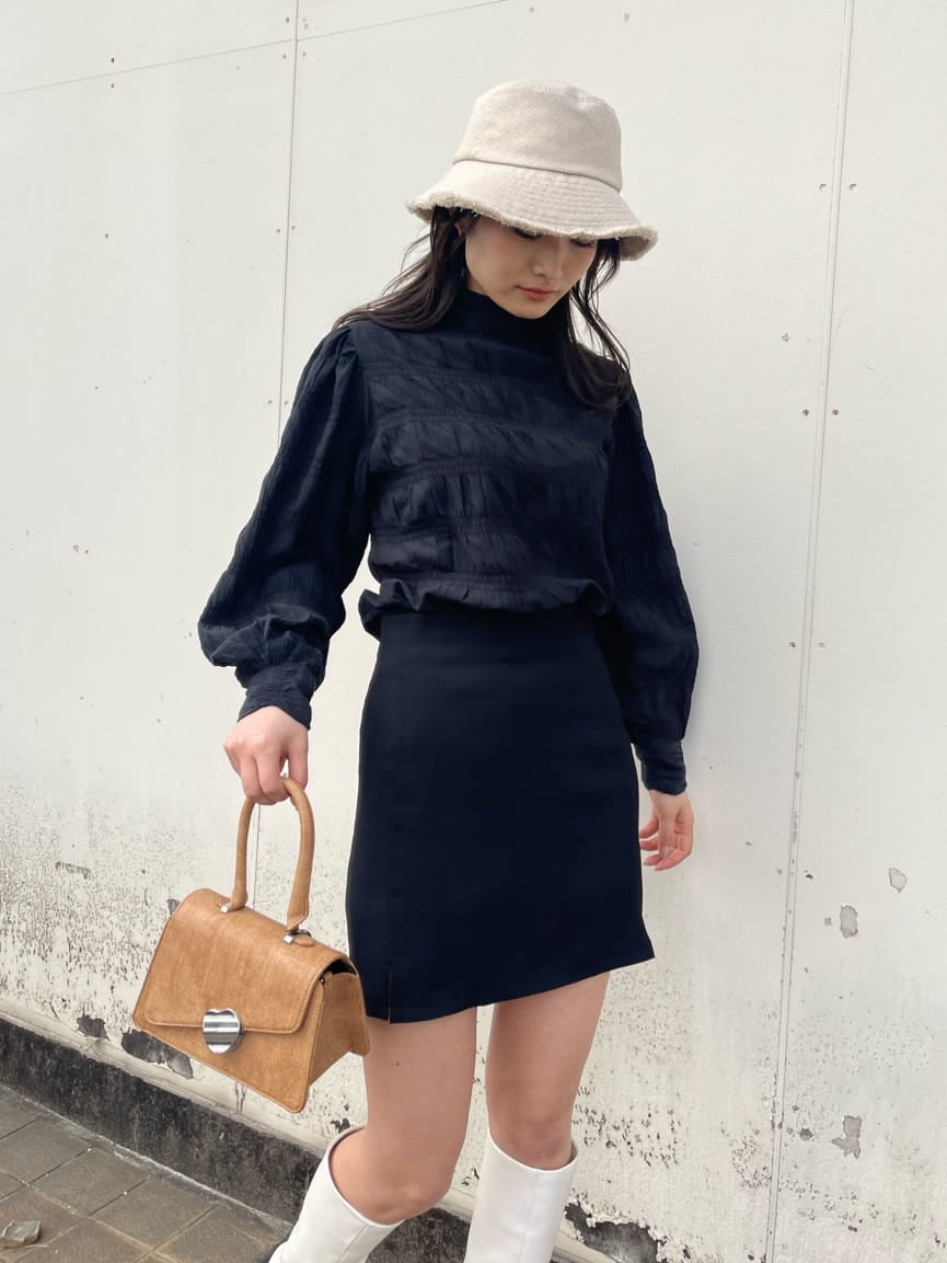 ホワイト系のブーツ、ブラウン系のハンドバッグ、ブラック系のシャツ/ブラウスを着用したレディースの春コーディネートの5枚目の写真