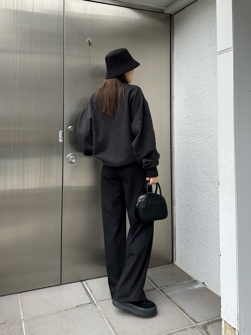 ブラック系のその他パンツ、ブラック系のハンドバッグ、ブラック系のTシャツ/カットソーを着用したレディースの冬コーディネートの2枚目の写真