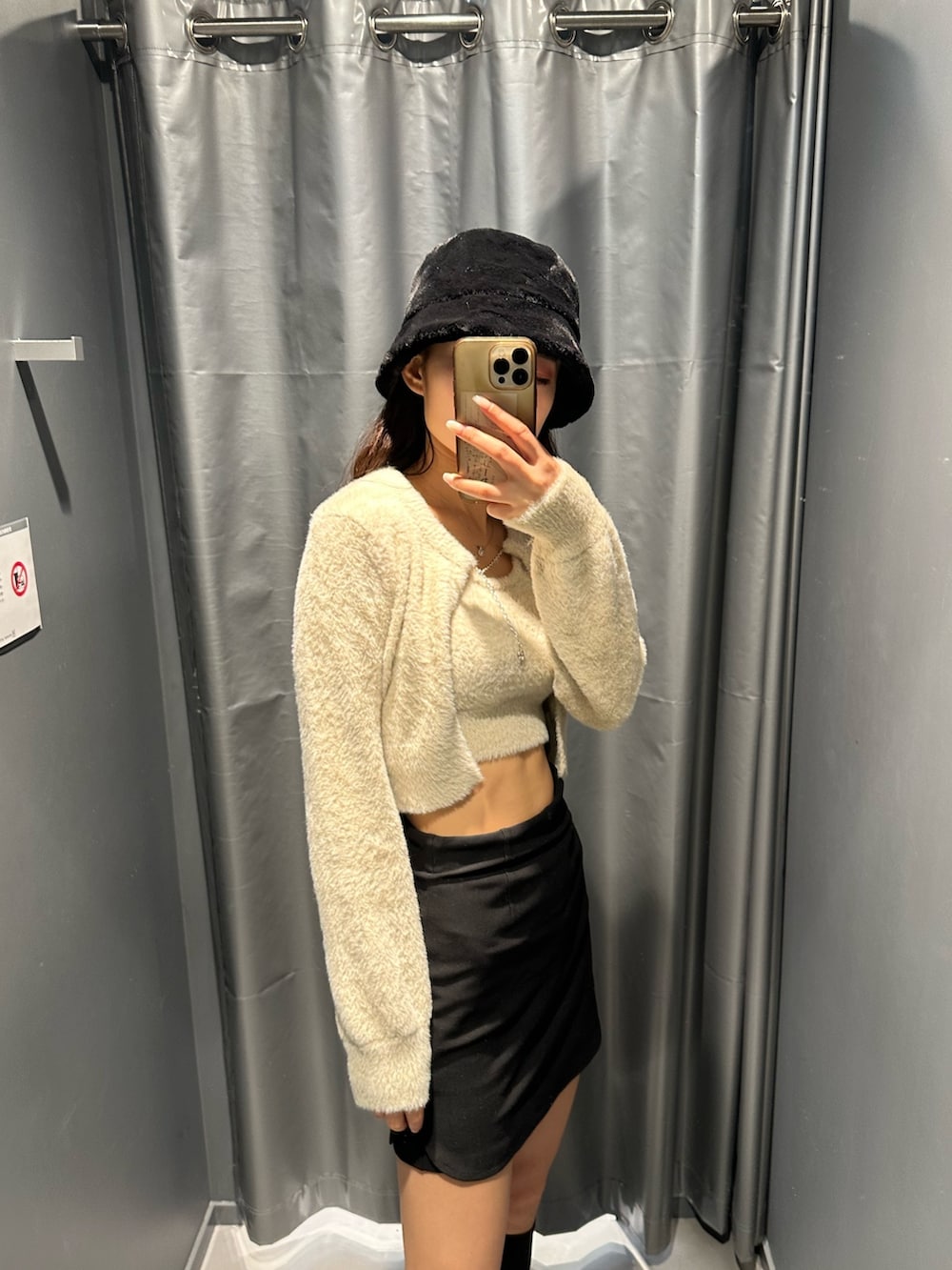 ブラック系のスカート、ホワイト系のニット/セーター、その他のブーツを着用したレディースの冬コーディネートの3枚目の写真