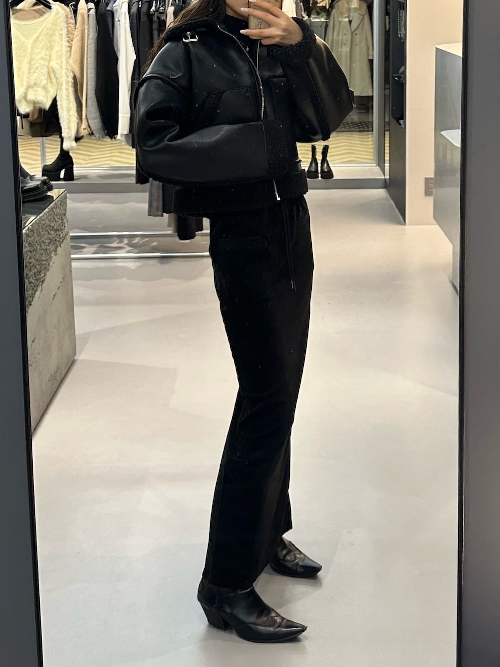 ブラック系のブルゾン、ブラック系のニット/セーター、ブラック系のブーツを着用したレディースの冬コーディネートの3枚目の写真