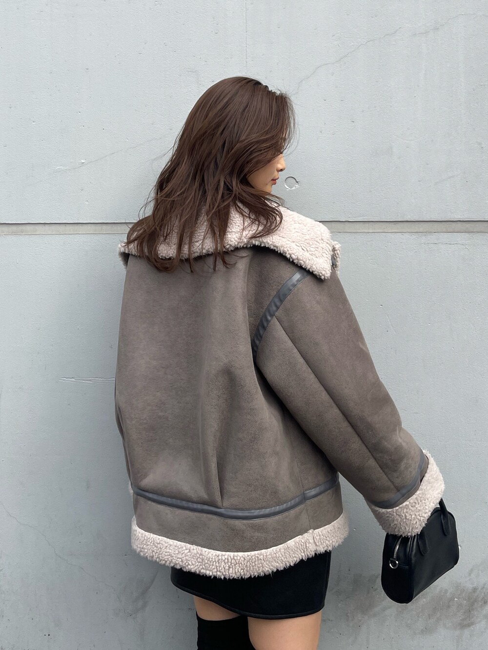 グレー系のブルゾン、その他のスカート、ブラック系のブーツを着用したレディースの秋コーディネートの7枚目の写真