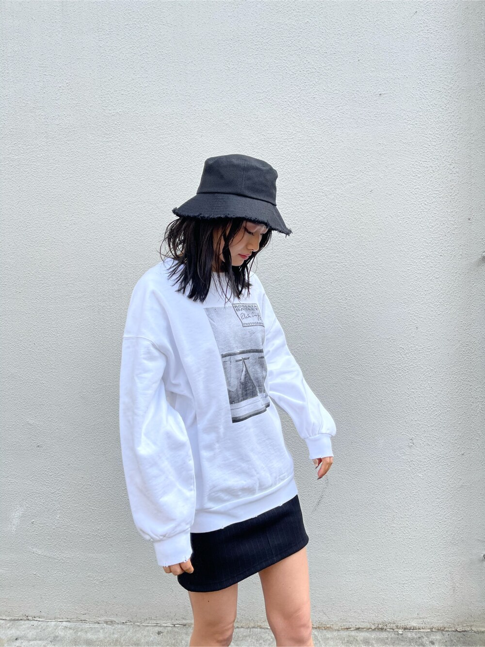 ブラック系のサンダル、ブラック系のスカート、ホワイト系のスウェットを着用したレディースの春コーディネートの3枚目の写真