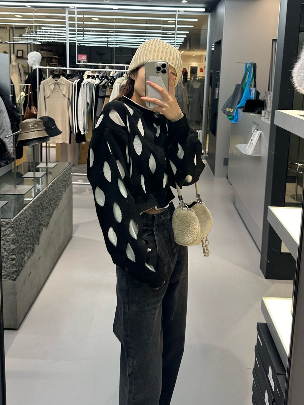 ブラック系のデニムパンツ、ホワイト系のハンドバッグ、ブラック系のローファーを着用したレディースの冬コーディネートの3枚目の写真