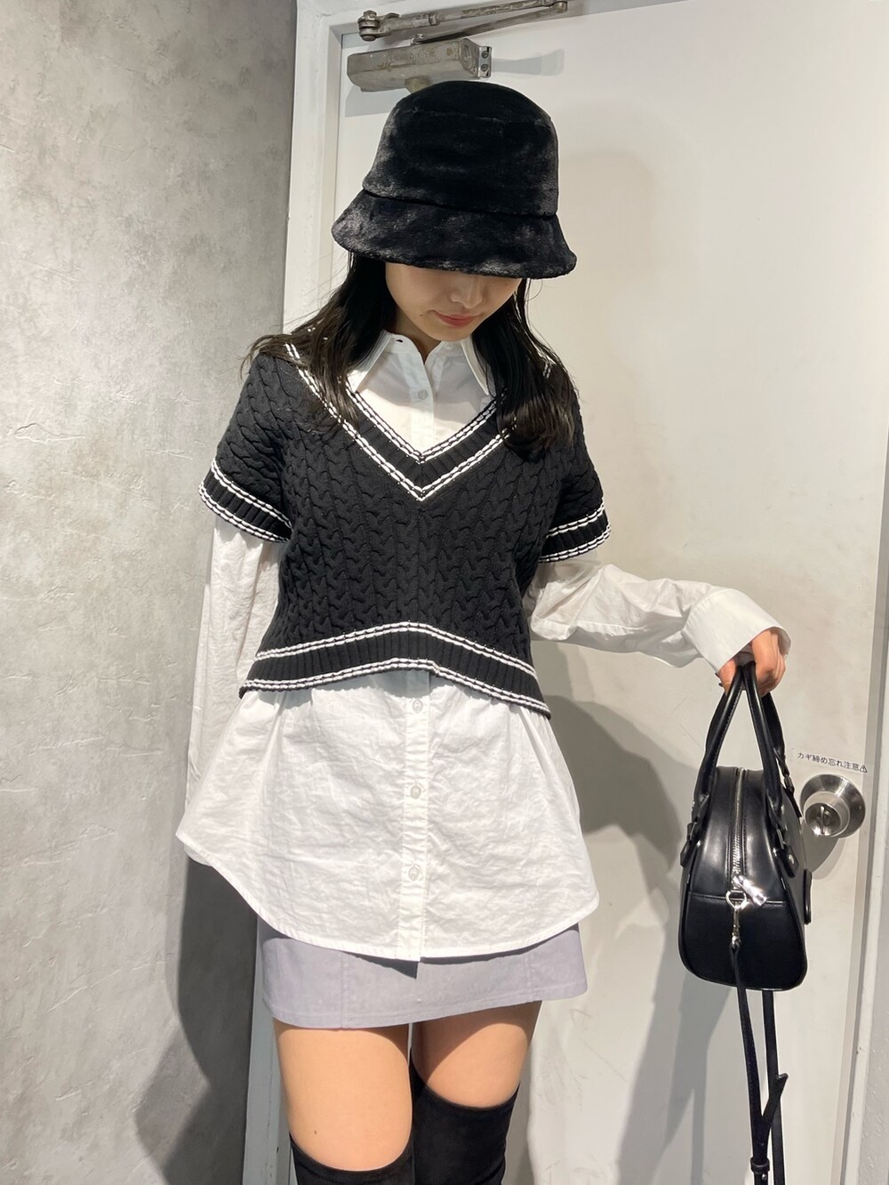 ブラック系のブーツ、ブラック系のベスト、ホワイト系のシャツ/ブラウスを着用したレディースの冬コーディネートの5枚目の写真