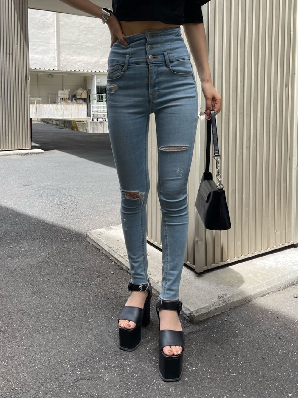 ブラック系のサンダル、ブラック系のTシャツ/カットソー、ブルー系のデニムパンツを着用したレディースの夏コーディネートの6枚目の写真