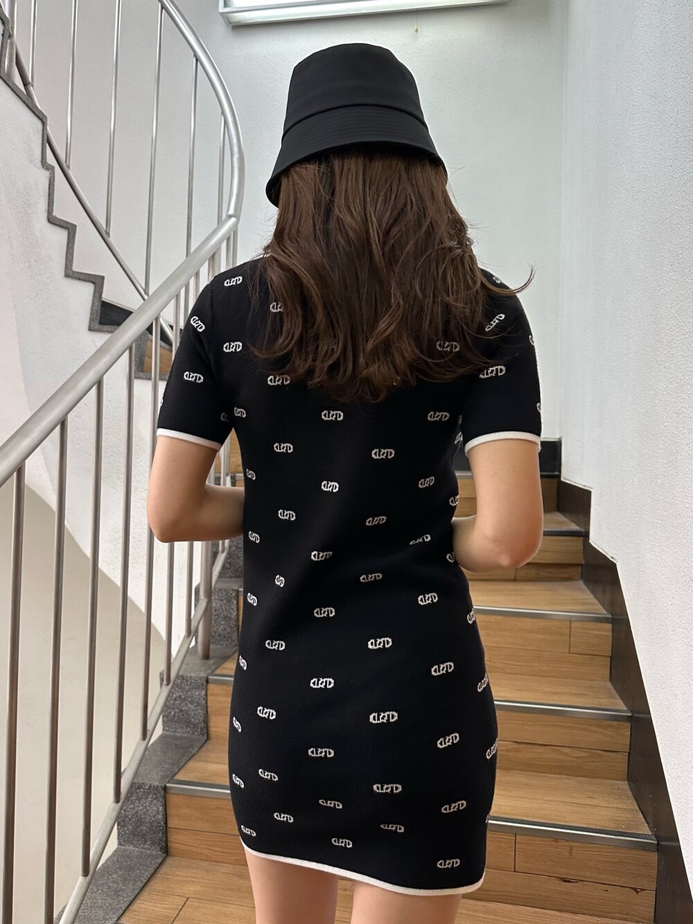 ブラック系のワンピース、ブラック系のサンダル、ブラック系のハットを着用したレディースの春コーディネートの6枚目の写真