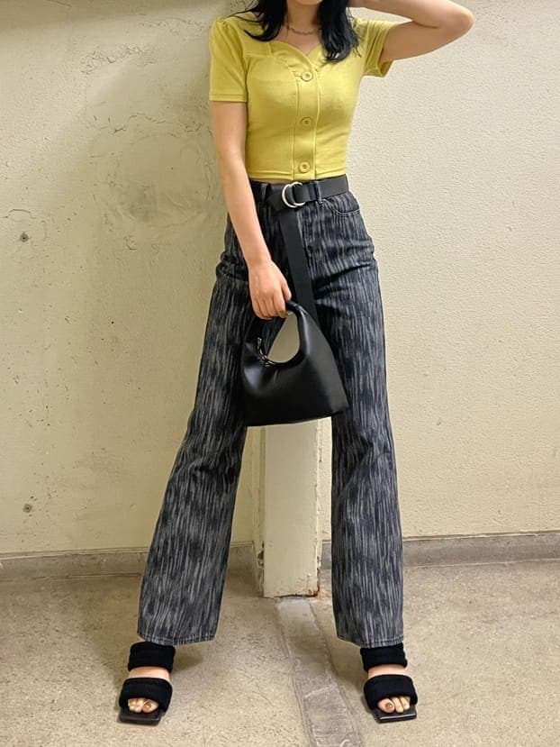 ブラック系のデニムパンツ、イエロー系のTシャツ/カットソー、ブラック系のサンダルを着用したレディースの夏コーディネートの2枚目の写真
