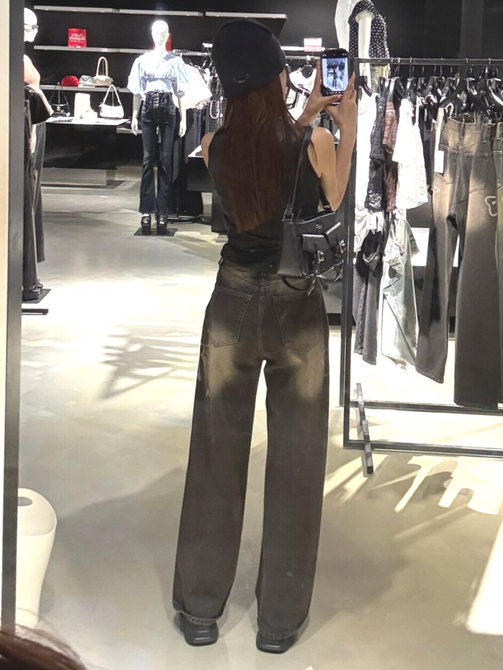 ブラック系のデニムパンツ、ブラック系のTシャツ/カットソー、グレー系のスニーカーを着用したレディースの夏コーディネートの3枚目の写真