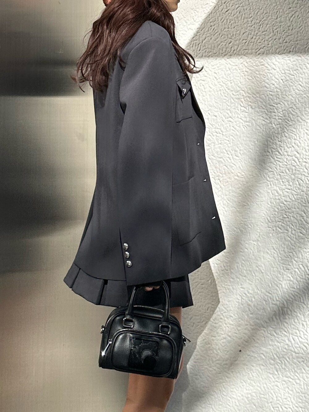 グレー系のスカート、ブラック系のスニーカー、その他のニット/セーターを着用したレディースの冬コーディネートの5枚目の写真