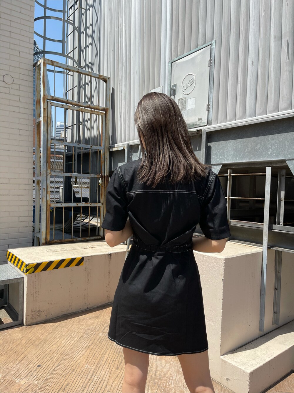 ブラック系のワンピース、ブラック系のサンダル、ホワイト系のショルダーバッグを着用したレディースの春コーディネートの3枚目の写真