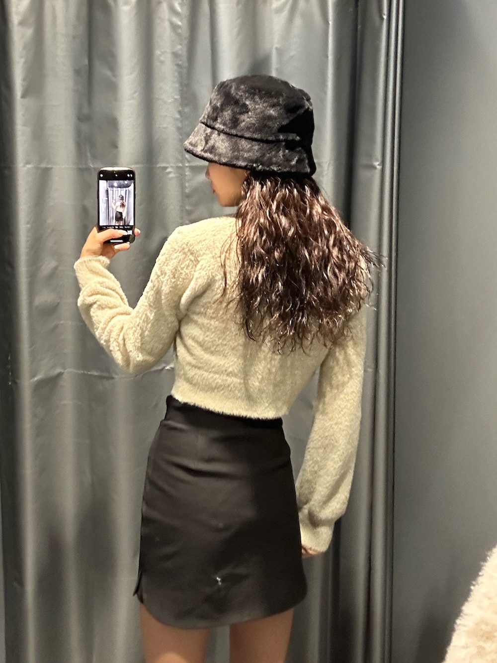 ブラック系のスカート、ホワイト系のニット/セーター、その他のブーツを着用したレディースの冬コーディネートの5枚目の写真