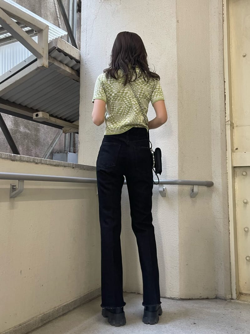 ブラック系のブーツ、ブラック系のハンドバッグ、ブラック系のデニムパンツを着用したレディースの春コーディネートの4枚目の写真