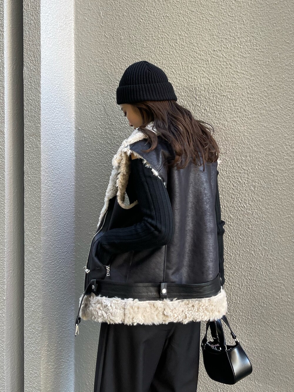 ブラック系のニット/セーター、ブラック系のその他パンツ、ブラック系のハンドバッグを着用したレディースの冬コーディネートの6枚目の写真