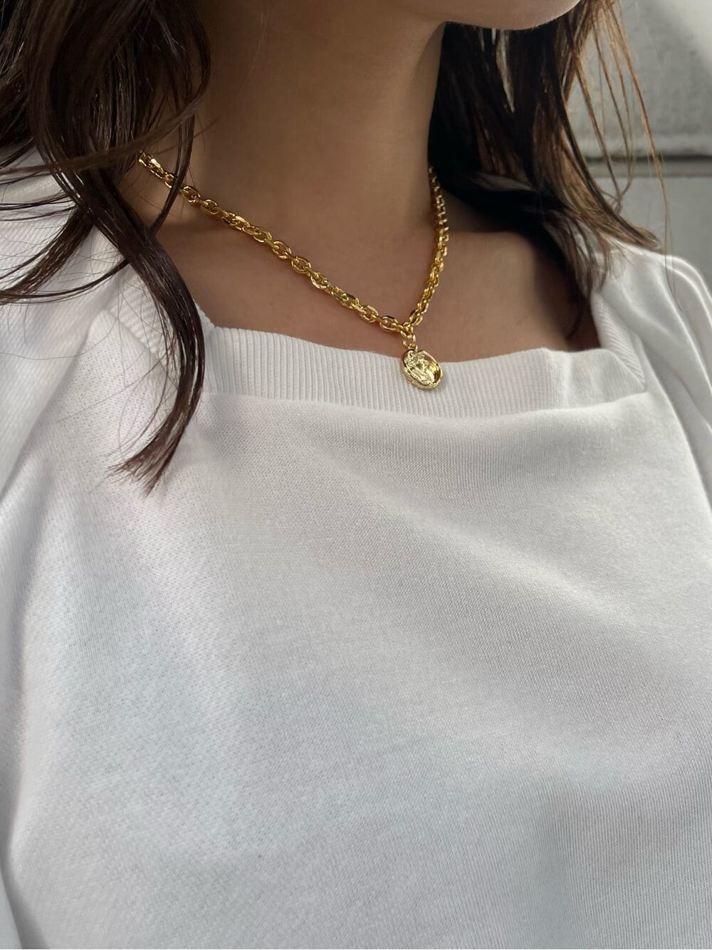 ブラック系のスカート、ホワイト系のTシャツ/カットソー、ブラウン系のハンドバッグを着用したレディースの冬コーディネートの8枚目の写真