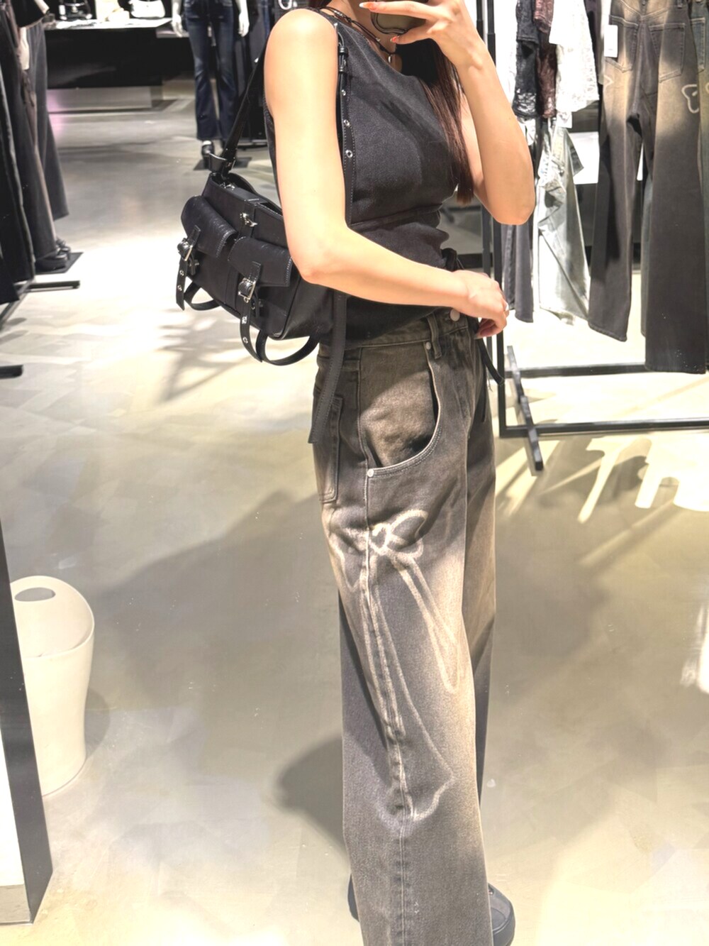 ブラック系のデニムパンツ、ブラック系のTシャツ/カットソー、グレー系のスニーカーを着用したレディースの夏コーディネートの7枚目の写真