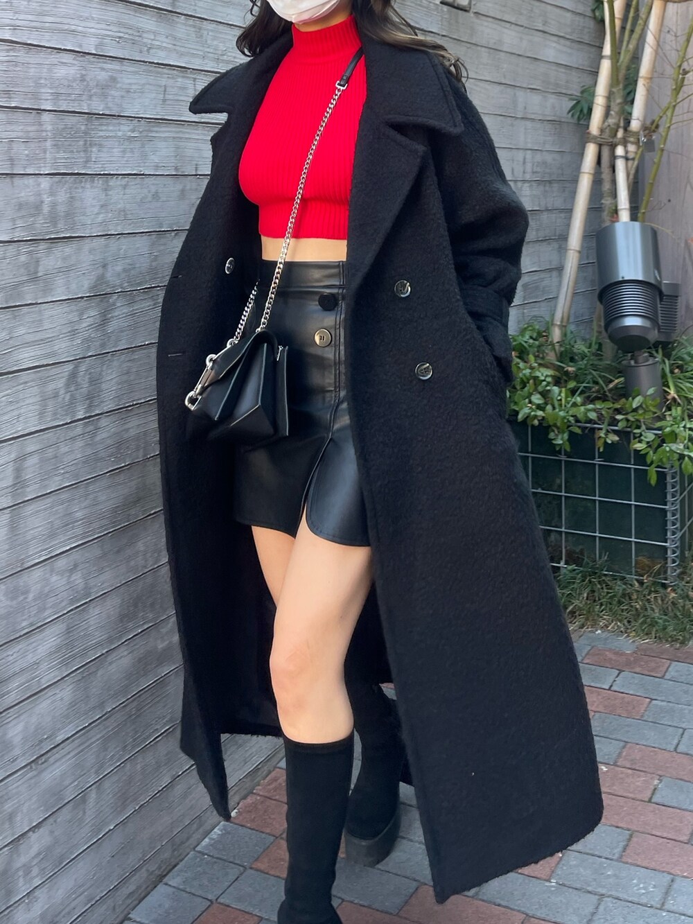 ブラック系のチェスターコート、その他のスカート、レッド系のニット/セーターを着用したレディースの冬コーディネートの6枚目の写真