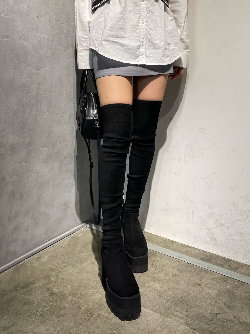 ブラック系のブーツ、ブラック系のベスト、ホワイト系のシャツ/ブラウスを着用したレディースの冬コーディネートの8枚目の写真